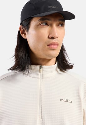 Mann mit schwarzer Kappe und beigefarbenem Odlo-Shirt.