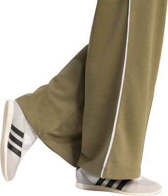 Grüne Damen-Hose mit weißen Streifen und weißen Sneakern. Grüne Damen-Hose mit weißen Streifen und weißen Sneakern.