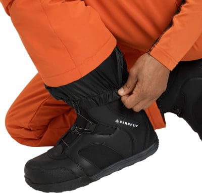 Mann passt die Hose einer Skihose über den Schuh an. Mann passt die Hose einer Skihose über den Schuh an.