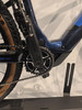 Detail eines E-Bike-Rahmens mit Kurbeln und Kette auf einem Ständer.