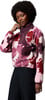 Frau mit Afro-Frisur in einer rosa Fleecejacke mit Blumenmuster.