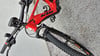 Ein rotes KTM E-Bike mit schwarzer Gabel und schwarzem Lenker auf Betonuntergrund.