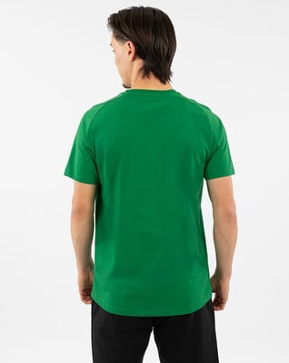 Ein Mann in einem grünen T-Shirt und einer schwarzen Hose von hinten fotografiert.