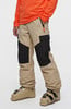 Skihose in Beige mit schwarzen Einsätzen und Skischuhen.
