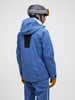 Mann in blauer Skijacke und Helm mit Brille.