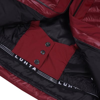 Detail des Innenraums einer dunkelroten Jacke mit Luhta-Logo und Knöpfen. Detail des Innenraums einer dunkelroten Jacke mit Luhta-Logo und Knöpfen.