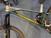Ein Mondraker Mountainbike mit Dämpfer und grünem Rahmen mit gelbem Schriftzug.