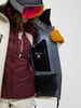 Skifahrerin in Jacke mit Weste und Brille, Detail der Innentasche.