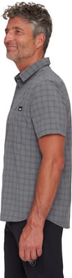Ein Mann in einem grauen karierten Kurzarmhemd und schwarzer Hose. Ein Mann in einem grauen karierten Kurzarmhemd und schwarzer Hose.