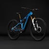 Ein blaues Mountain-Elektrofahrrad mit Federung und schwarzen Rädern auf dunklem Hintergrund.