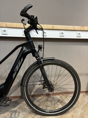 Ein schwarzes KTM E-Bike mit Vorderradfederung und Scheibenbremsen. Ein schwarzes KTM E-Bike mit Vorderradfederung und Scheibenbremsen.
