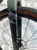 Detail einer Fahrrad-Vordergabel mit grafischem Muster und Bremsscheibe.
