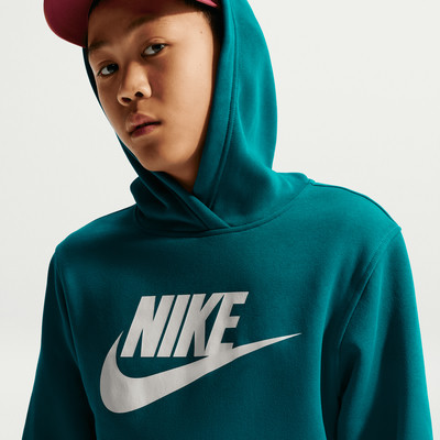 Ein Junge in einem dunkel-türkisfarbenen Kapuzenpullover mit Nike-Logo.