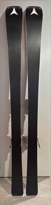Zwei schwarze Skier mit weißem Logo und Metallbindung stehen nebeneinander.