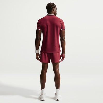 Ein Mann in dunkelroter Sportkleidung steht mit dem Rücken zur Kamera. Ein Mann in dunkelroter Sportkleidung steht mit dem Rücken zur Kamera.