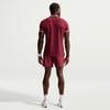 Ein Mann in dunkelroter Sportkleidung steht mit dem Rücken zur Kamera.
