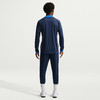 Rückansicht eines Mannes in dunkelblauer Sportkleidung mit blauem Kragen.