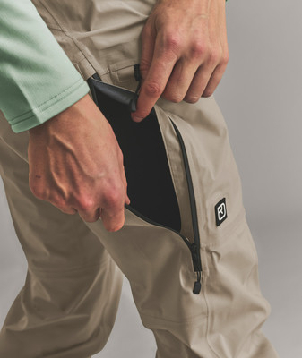 Ein Mann steckt seine Hand in eine Hose mit schwarzem Futter. Ein Mann steckt seine Hand in eine Hose mit schwarzem Futter.
