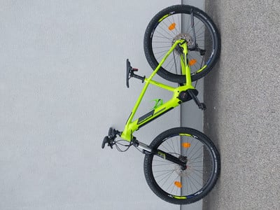 Ein grünes E-Bike lehnt an einer grauen Wand, Nahaufnahme von Rahmen und Rädern. Ein grünes E-Bike lehnt an einer grauen Wand, Nahaufnahme von Rahmen und Rädern.