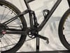 Detail eines Carbon-Mountainbikes mit Dämpfer und Antrieb.