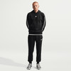 Ein Mann in schwarzer Nike-Kleidung mit weißen Streifen an Ärmeln und Hosen.
