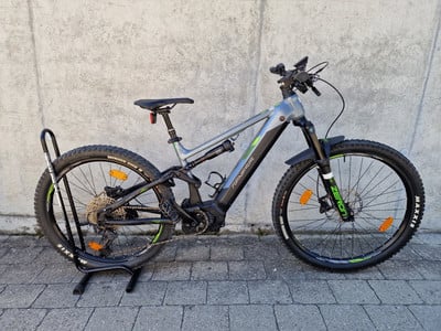 Ein Genesis E-Mountainbike mit Vollfederung steht auf einem Ständer. Ein Genesis E-Mountainbike mit Vollfederung steht auf einem Ständer.