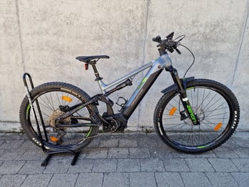 Ein Genesis E-Mountainbike mit Vollfederung steht auf einem Ständer.