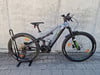 Ein Genesis E-Mountainbike mit Vollfederung steht auf einem Ständer.