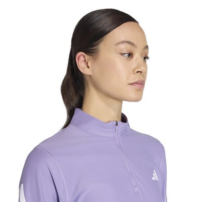 Modell látható lila Adidas logós hosszú ujjú felsőben.