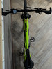 Ein grünes E-Bike mit Display am Lenker hängt an der Wand.