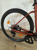 Das Hinterrad eines Fahrrads mit orangefarbenem Reflektor und Schaltwerk.
