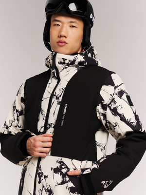 Ein Mann in einer Skijacke mit schwarzem Helm und Brille auf dem Kopf. Ein Mann in einer Skijacke mit schwarzem Helm und Brille auf dem Kopf.