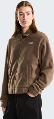 Eine Frau in einer braunen Fleecejacke mit The North Face Logo und schwarzer Hose. Eine Frau in einer braunen Fleecejacke mit The North Face Logo und schwarzer Hose.
