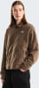 Eine Frau in einer braunen Fleecejacke mit The North Face Logo und schwarzer Hose.