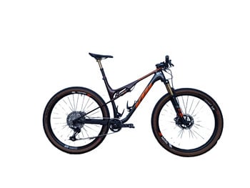Ein KTM Mountainbike mit Federung und braunen Reifen auf weißem Hintergrund.
