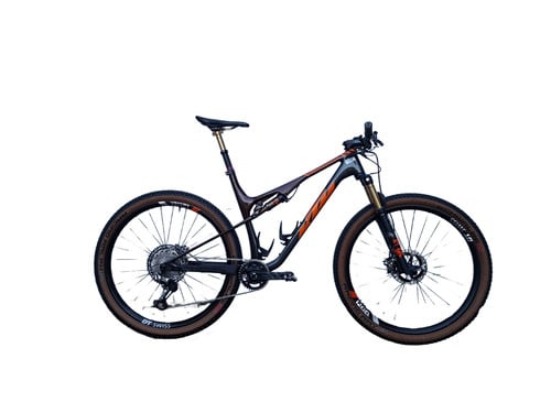 Ein KTM Mountainbike mit Federung und braunen Reifen auf weißem Hintergrund.