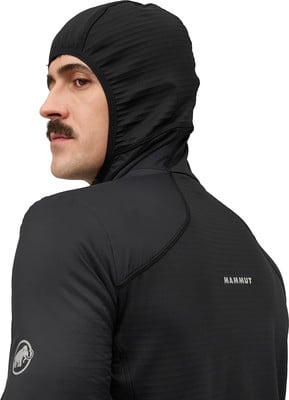 Mann im schwarzen Kapuzenpullover mit Mammut-Logo auf dem Rücken. Mann im schwarzen Kapuzenpullover mit Mammut-Logo auf dem Rücken.