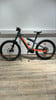 Graues E-Bike mit orangefarbenen Akzenten auf Holzboden.