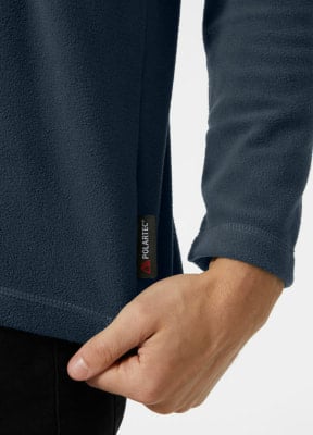 Detail eines Fleece-Bekleidungsstücks mit Polartec-Logo, das von einem Mann getragen wird. Detail eines Fleece-Bekleidungsstücks mit Polartec-Logo, das von einem Mann getragen wird.