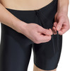 Ein Mann zieht die Kordel einer schwarzen Badehose fest.