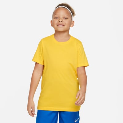 Ein Junge in einem gelben T-Shirt und blauen Shorts lächelt. Ein Junge in einem gelben T-Shirt und blauen Shorts lächelt.