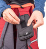Eine Hand schließt eine kleine schwarze Klettverschlusstasche am Rucksack.