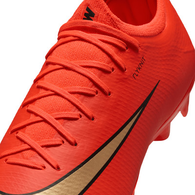 Orangene Fußballschuhe mit Schnürsenkeln und goldenem Nike-Logo.