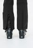 Detail einer Skihose mit geöffnetem Reißverschluss und Skischuhen.