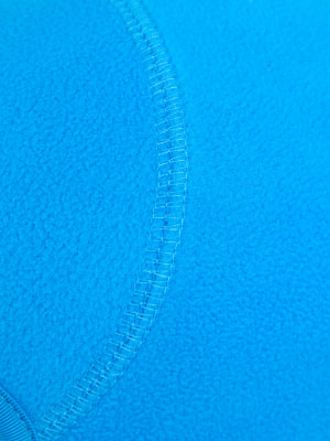 Blauer Stoff mit Naht, Nahaufnahme der Textur.