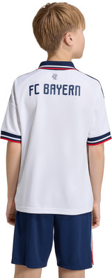 Junge von hinten in weißem Fußballtrikot mit FC Bayern Schriftzug. Junge von hinten in weißem Fußballtrikot mit FC Bayern Schriftzug.