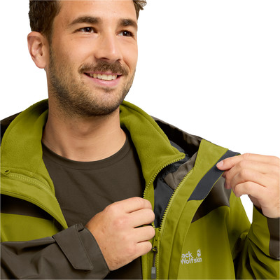 Ein Mann schließt eine grüne Jacke mit dunklen Streifen und Fleece-Futter. Ein Mann schließt eine grüne Jacke mit dunklen Streifen und Fleece-Futter.