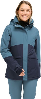 Eine Frau in einer blauen Winterjacke mit dunkelblauen Einsätzen und Kapuze. Eine Frau in einer blauen Winterjacke mit dunkelblauen Einsätzen und Kapuze.