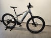 Ein graues KTM E-Mountainbike mit Vollfederung auf einem Ständer.