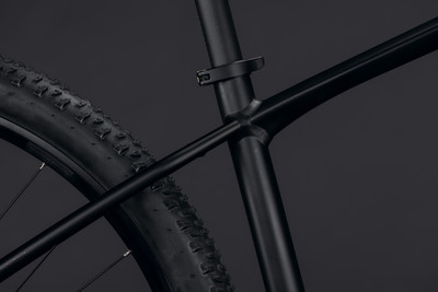 Detail eines schwarzen Mountainbike-Rahmens mit Reifen und Sattelstütze.